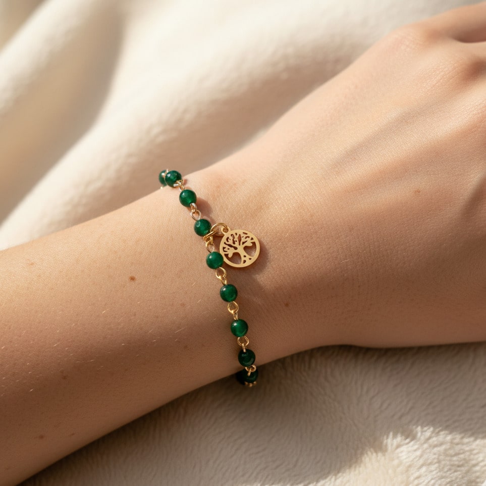 [variant: Vouves Bracelet] Gold Vouves Olive Tree charm bracelet with green gemstone beads worn on wrist in soft natural light