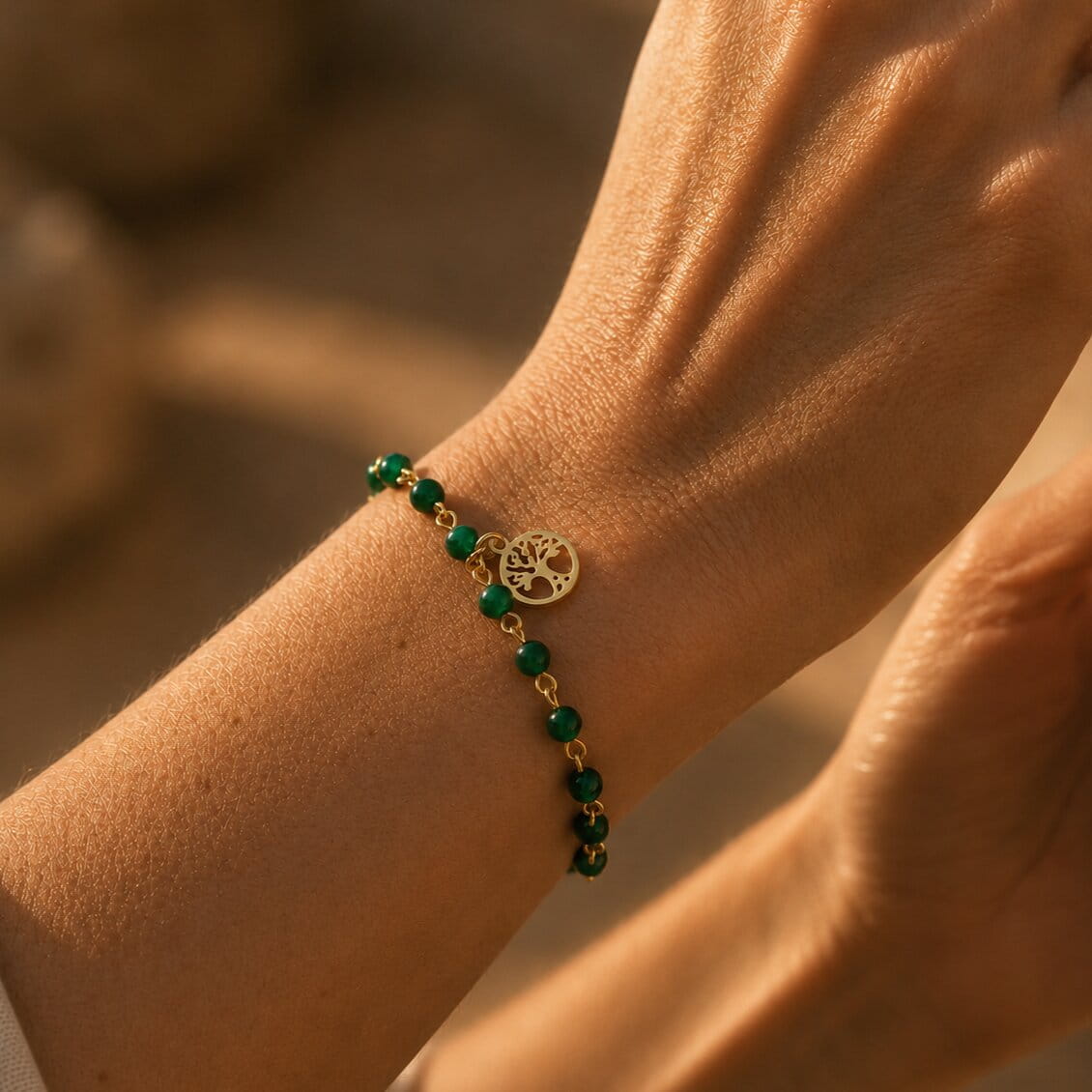 [variant: Vouves Bracelet] Close-up of a wrist wearing a green beaded bracelet