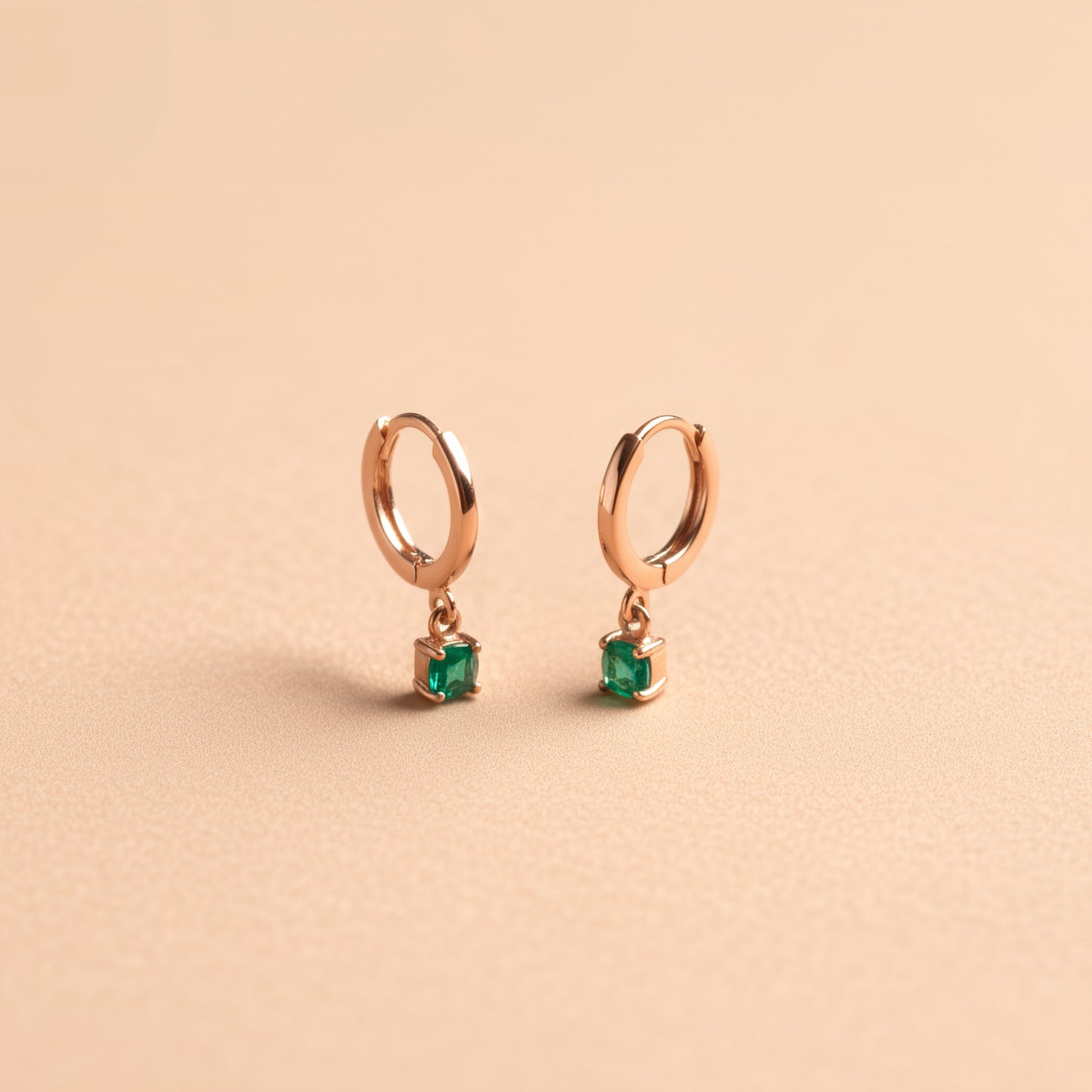 [variant:Vouves Earrings] Gold hoop earrings with green chalcedony gemstone drops displayed on a soft beige background