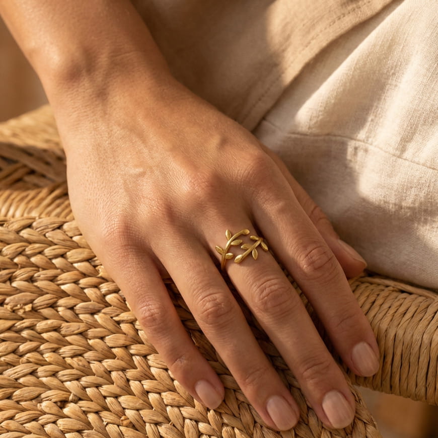 [variant:Vouves Ring] Mediterranean woman wearing a gold ring on a woven surface